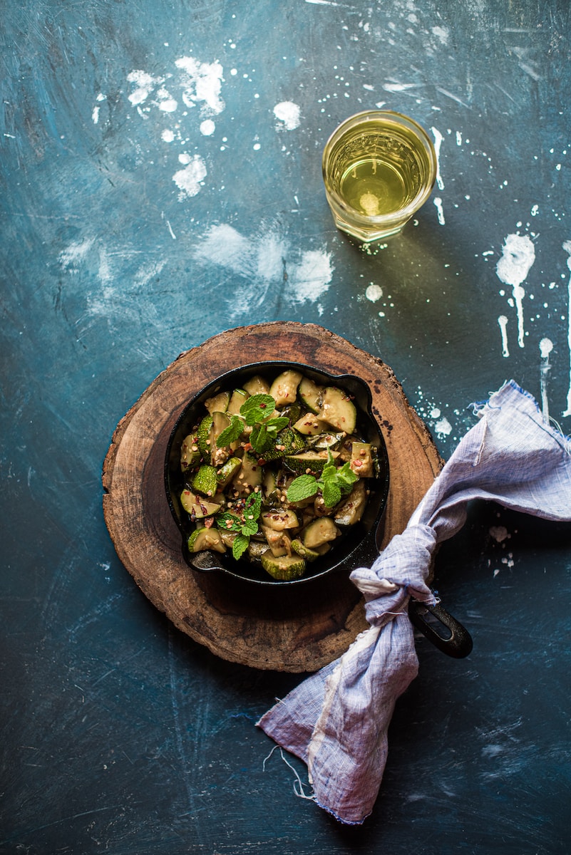 green vegetable in brown bowl beside clear drinking glass