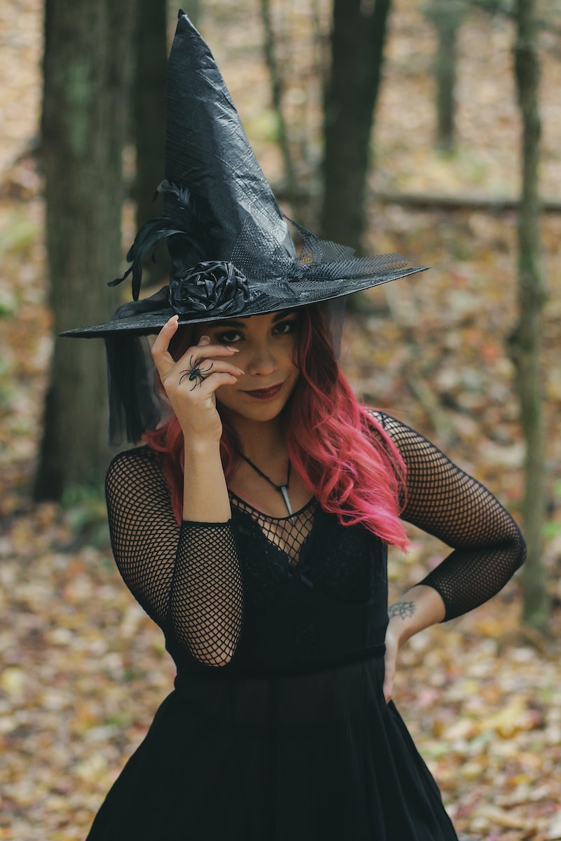 a woman with red hair wearing a witches hat