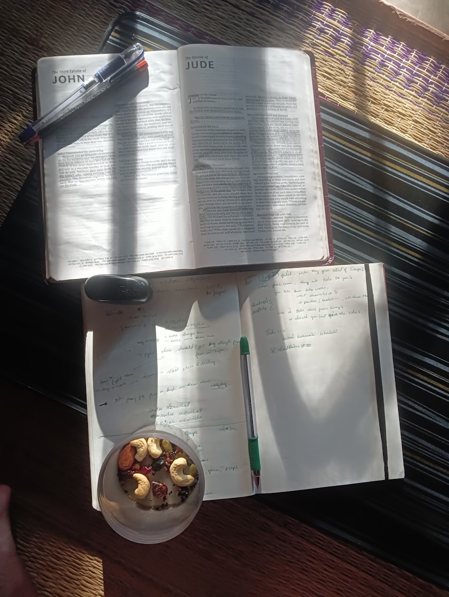 An open book sitting on top of a table next to a bowl of food
